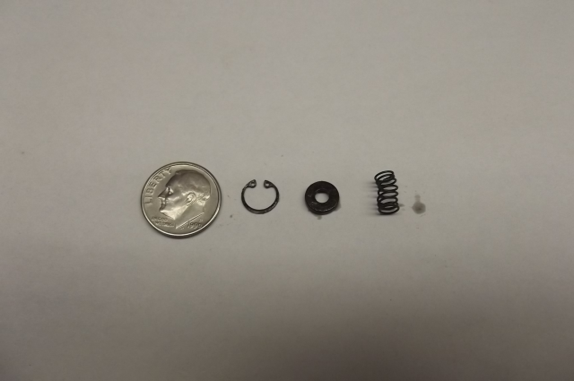 Circlip, seating washer, and spring with U.S. dime for size reference