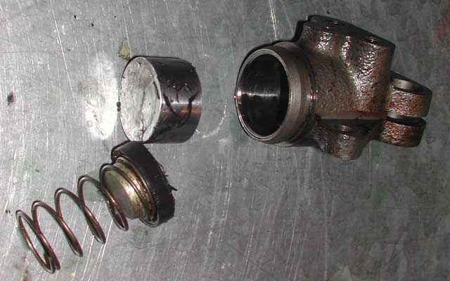 Newly dismantled wheel cylinder showing shaved rim of cylinder cup and sliced pieces on the side of the piston
